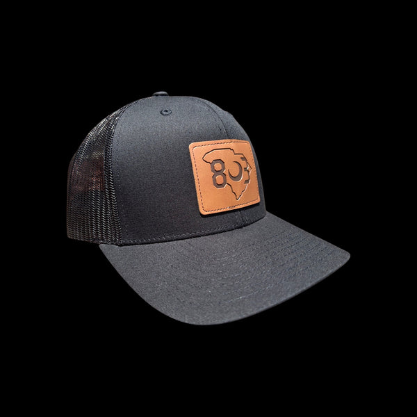 803 Yupoong Black/Black Leather Patch Trucker